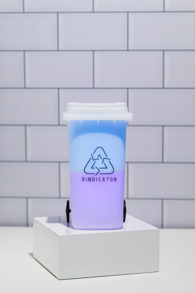 Bindicator lamp glowing in bin colours against a tiled kitchen wall